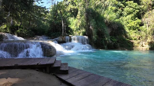 Video footage of a natural swimming hole in a tropical rainforest with waterfalls a in Luang Prabang, Laos