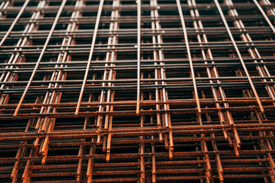Stacked reinforcement steel mesh rods at a construction site. Concept of building foundation, concrete reinforcement, structural engineering, industrial materials, and heavy construction.