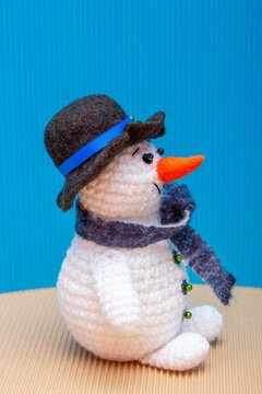 Snowman knitted from yarn, set against a colorful background