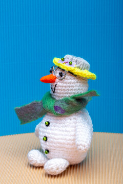 Snowman knitted from yarn, set against a colorful background
