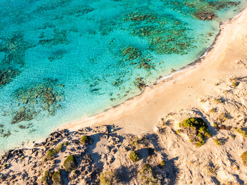 High angle drone view of Elafonisi sandy beach shoreline with crystal clear turquoise sea in Crete, Greece.