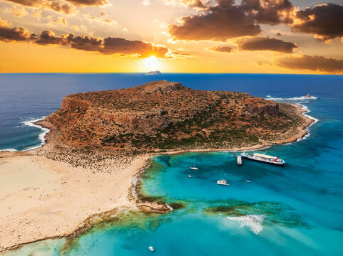Aerial photo of Balos beach lagoon with turquoise shallow water, white sand and peninsula in Crete, Greece at sunset