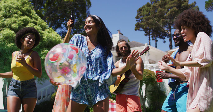 Diverse group of friends having fun and dancing at a pool party