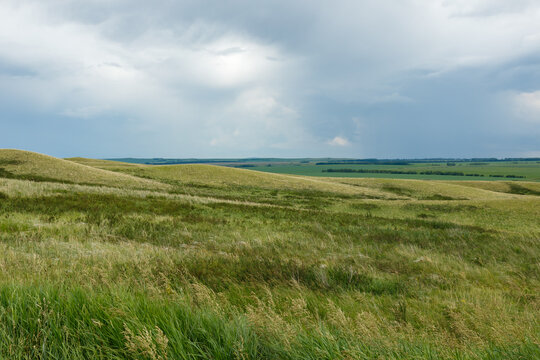 Rolling green hills and grass steppe landscape in Bashkortostan Russia under cloudy sky
