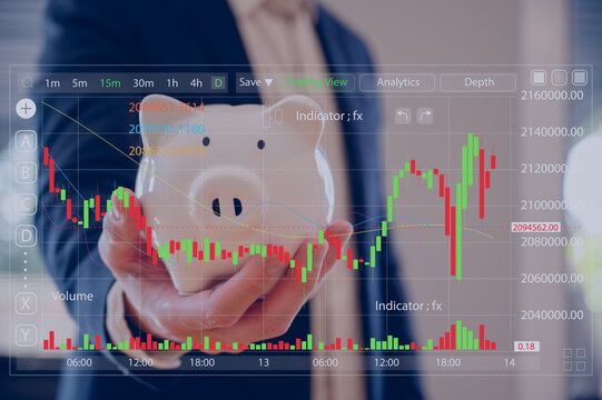 Businessman hand holding piggy bank on wood table in business finance and saving money investment concept.