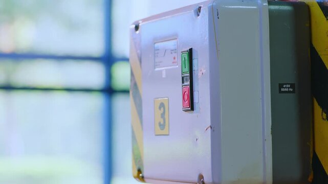 Industrial control panel close up with blurred factory background