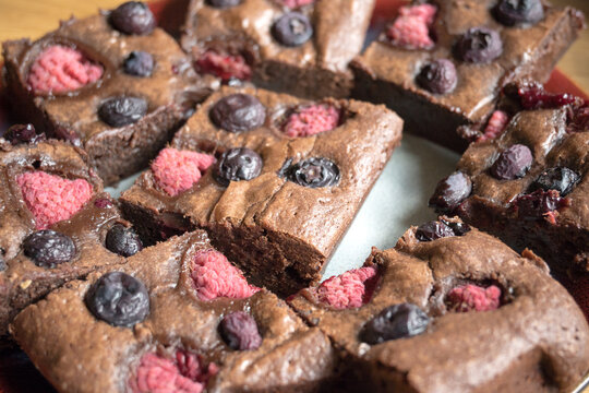 Homemade chocolate brownies with raspberries and blueberries.

