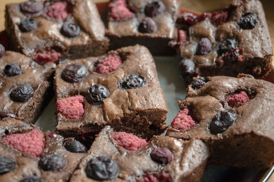 Homemade chocolate brownies with raspberries and blueberries.
