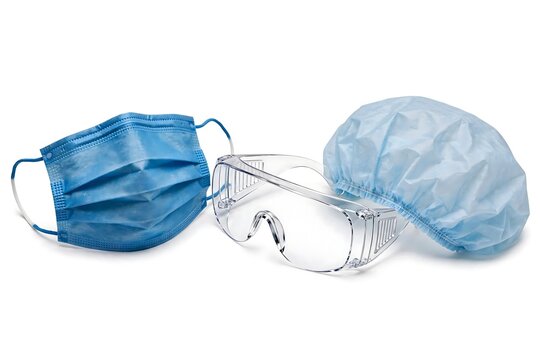 Medical protective equipment including a blue face mask, safety goggles, and a hair cap isolated on white background