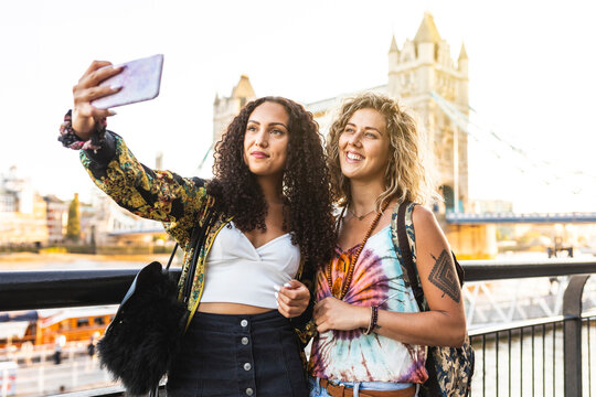 UK, London, two friends taking a selfie with Tower Bridge in background