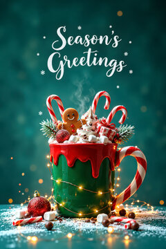 Season's Greetings Christmas card featuring a festive green mug topped with red icing, candy canes, gingerbread cookies and pine sprigs, surrounded by glowing lights on a teal background