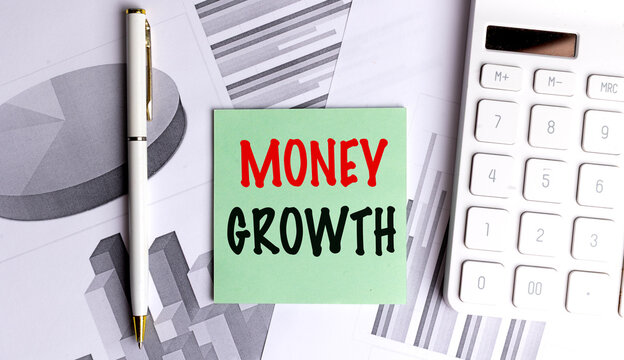 Money growth concept with calculator, pen and financial charts, illustrating investment, wealth and economic progress