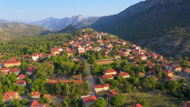Aerial pullback over Ormana village toward forested Taurus Mountains, Antalya