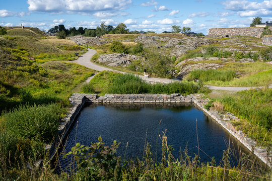Rocky coastal landscape and historic stone fortifications on a sunny day in Helsinki