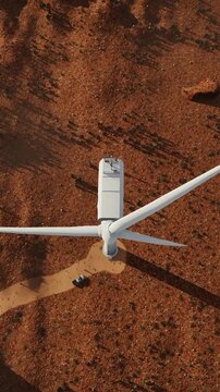 Aerial view of large wind turbine in remote desert landscape a high angle