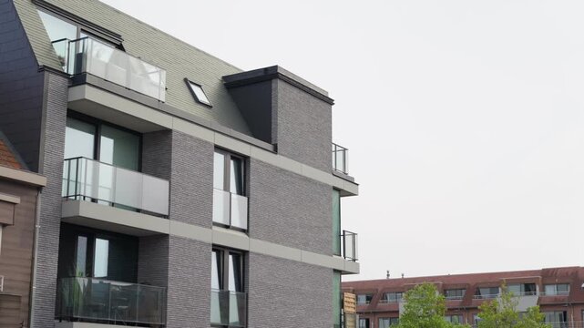 Gray brick apartment building with glass balconies residential district slow motion