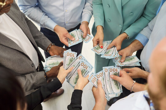 Business team employees holding cash money dollars. Colleagues exchange dollar banknotes for payday salary bonus and payroll compensation at work. Team rewards performance and motivation.