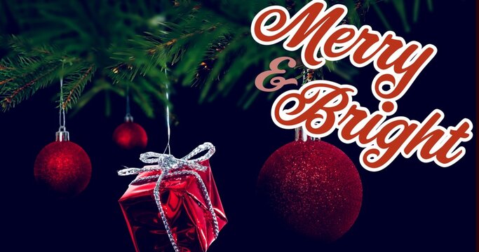 Hanging glittery red bauble with foil-wrapped gift from evergreen branch, showing Merry  and  Bright