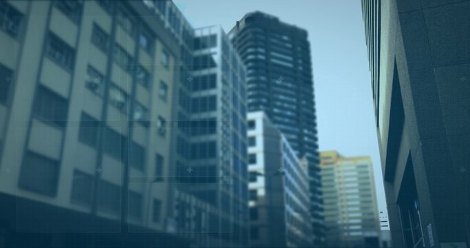Framing dark cylindrical tower and glass midrises rising in downtown canyon, showing grid windows