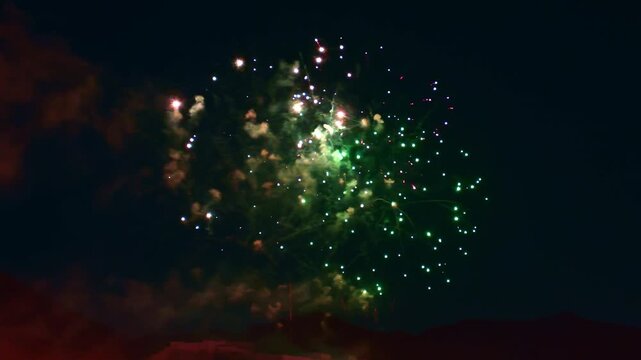 Colorful, magical fireworks illuminate the night sky during a festive celebration, vibrant explosions, bursts of beautiful, fountain-like trails of light, smoke. Pyrotechnic light-show technologies.