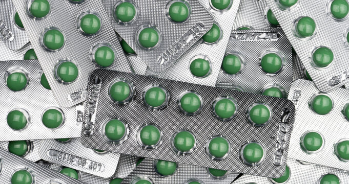 Full frame green round pills in blister pack. Prescription medicine. Top view of green tablet pills. Pharmaceutical manufacturing industry. Health care and medical concepts. Vitamin and supplement.