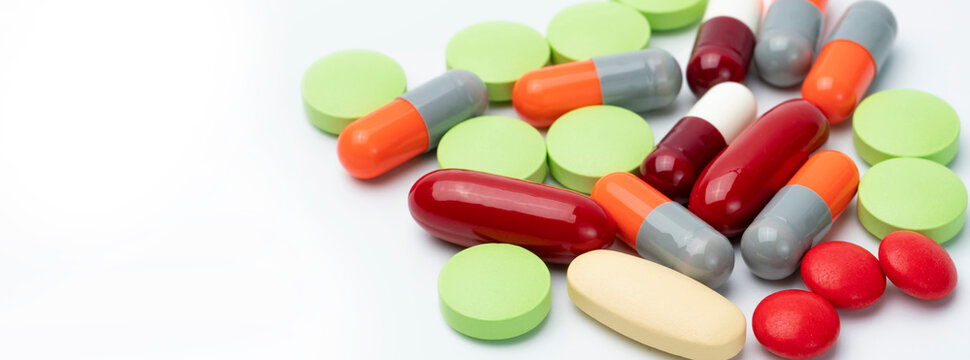 Mixed tablets and capsules on a white background with copy space, a pharmacy concept for prescription medicine, vitamins and supplements, showing drug interactions and medication use in senior care