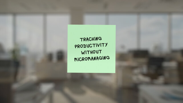 Memo with the words "tracking productivity without micromanaging" in the front, superimposed on a blurred background showing an cubicle-free environment.