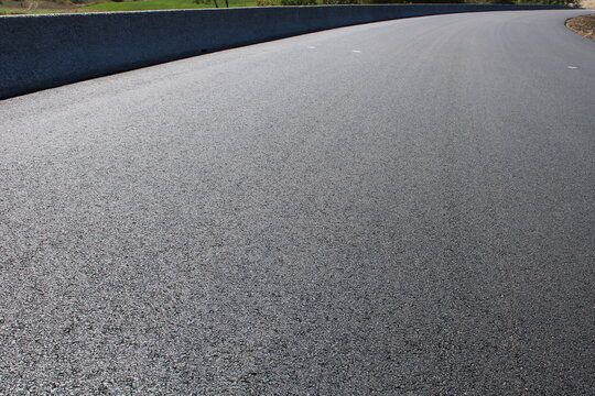 Perspective sur un enrob&eacute; bitumineux neuf et barri&egrave;re de s&eacute;curit&eacute; en b&eacute;ton, infrastructure routi&egrave;re