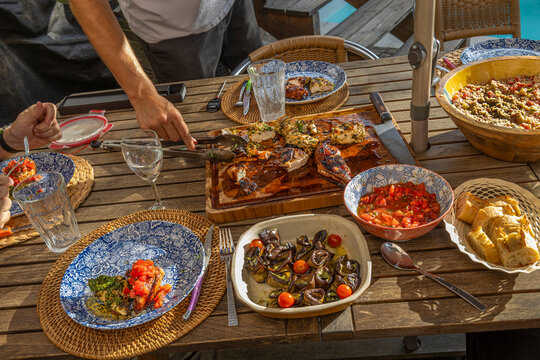 Group Enjoys Meal Outdoors at a Dining Table