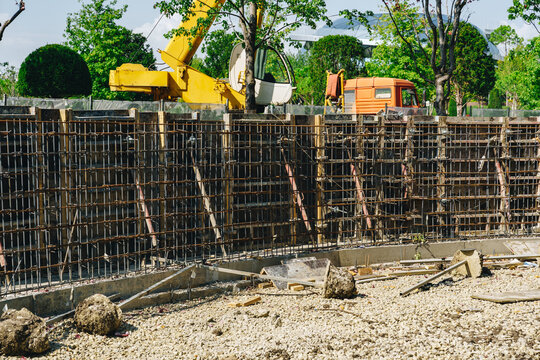 Construction work on a building site with heavy machinery and foundations being prepared