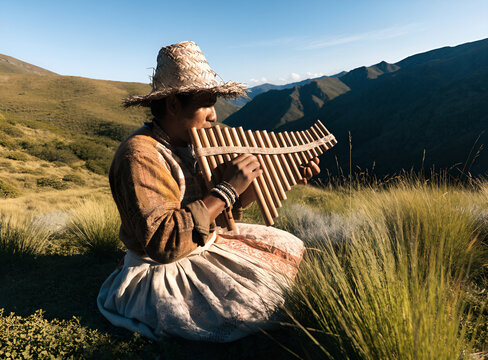 Musician playing a traditional pan flute in an Andean meadow