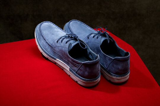 Men's blue lace-up shoes on a red background