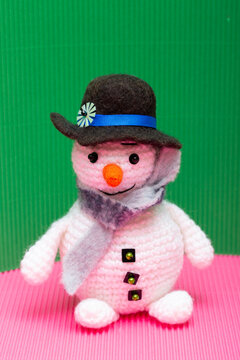 Snowman knitted from yarn, set against a colorful background