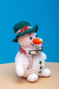 Snowman knitted from yarn, set against a colorful background