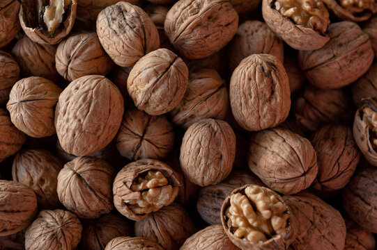 Inshell walnut pile harvest background. Organic cracked nut kernel market display
