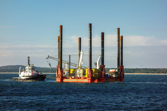 Tugboat Towing Offshore Jack-Up Construction Barge Platform. Offshore Construction, Marine Industry and Energy Infrastructure