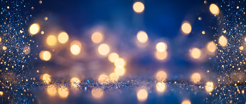 Glittering fairy lights illuminate dark blue festive background with magical golden orbs. Luminous reflections mirror warm glowing sparkles upon shiny tabletop during joyful winter season.