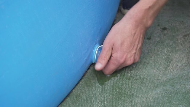Draining water from the pool, Man opens a hole to drain the blue pool 