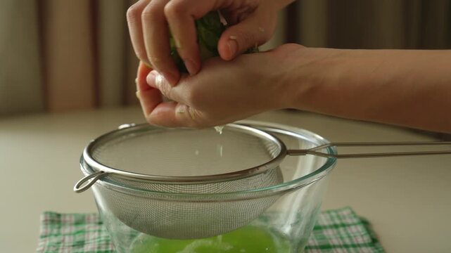 Wringing cucumber slices with both hands over a sieve