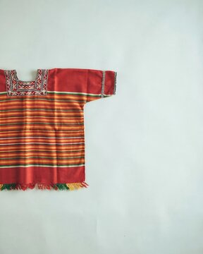 Traditional handmade indigenous mexican shirt with vibrant colorful stripes and intricate woven patterns