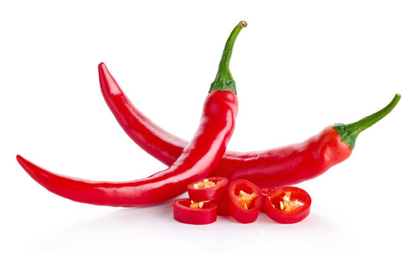 Two whole and chopped red hot chili peppers on white background