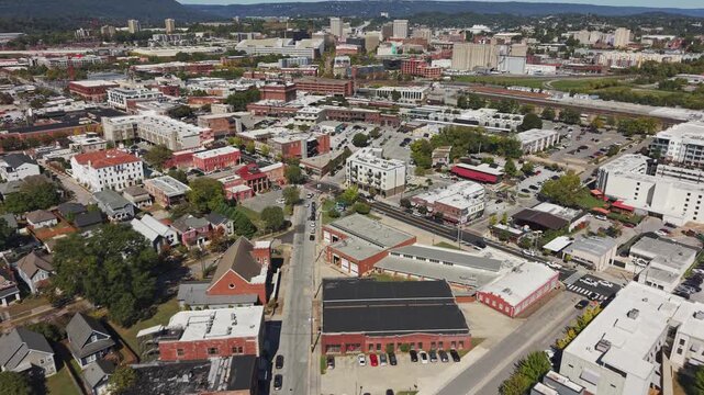 Drone aerial of downtown city of Chattanooga Tennessee in United States with roads, buildings, museums, and attractions along highway and with Choo Choo signage on top building rooftops in moving shot