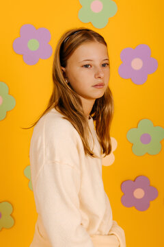 Girl looking away on yellow floral background