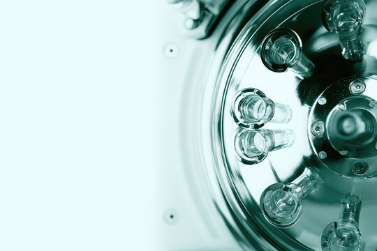Laboratory centrifuge rotor with balanced vial holder and cool white negative space for scientific sample processing