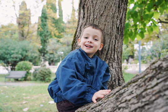 Smiling Boy Leaning Against Tree