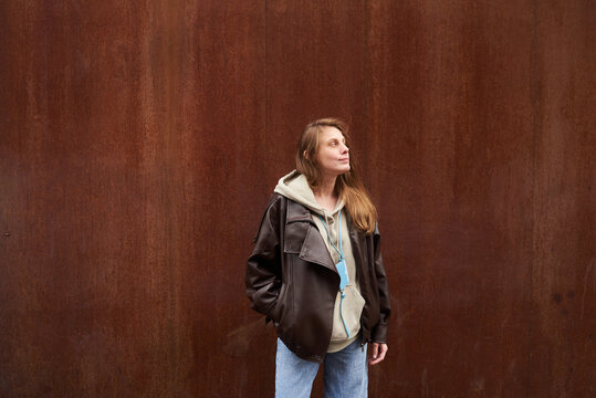 Woman wearing leather jacket standing outdoors.
