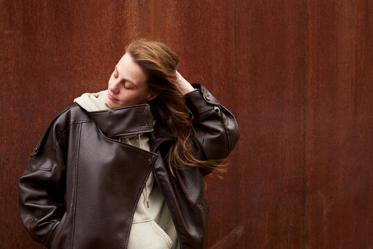 Woman adjusts her hair while standing in the wind.