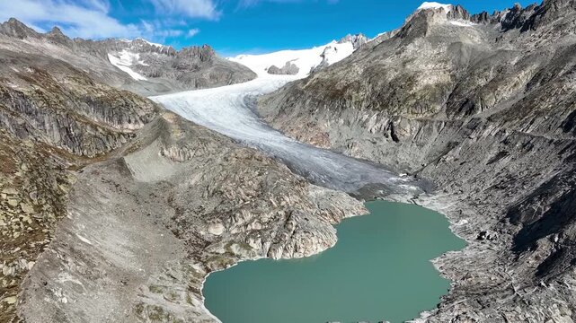Scenic aerial drone footage of the retreating Rhone Glacier (Rhonegletscher) located near the winding Furka Pass road in Valais, Switzerland. Breathtaking landscape of the High Alps, showcasing dramat