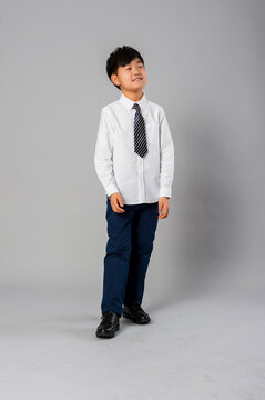 Portrait of handsome asian schoolboy in formal uniform in studio