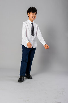 Portrait of handsome asian schoolboy in formal uniform in studio